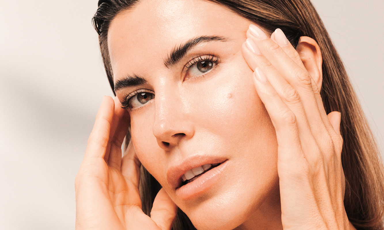 Frau mit strahlendem Hautbild berührt ihr Gesicht