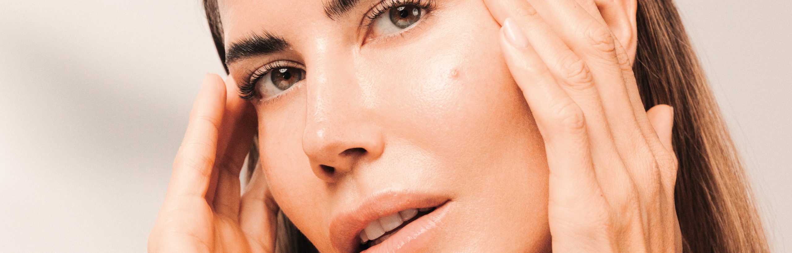 Frau mit strahlendem Hautbild berührt ihr Gesicht